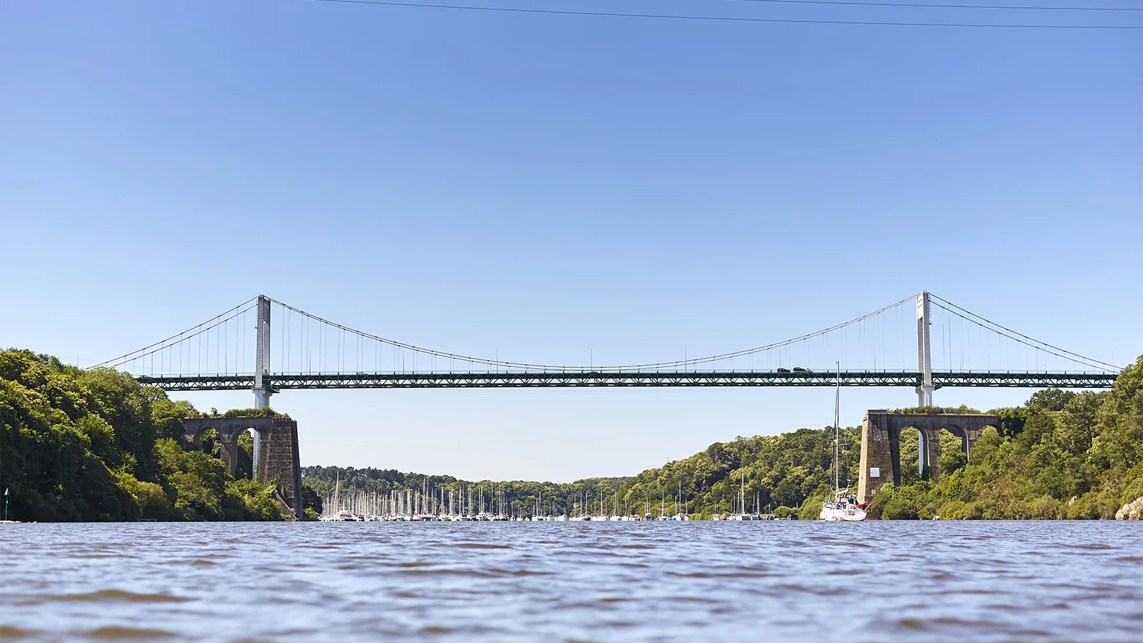 Le pont de La Roche-Bernard enjambant la Vilaine, voiliers au mouillage et rives boisées — Bulles et Cocon