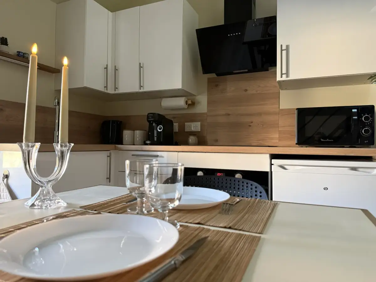 Table dressée aux chandelles devant la cuisine équipée — Bulle Rochoise, Bulles et Cocon